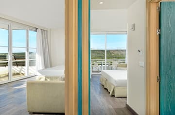 a room with two beds and a view of the landscape