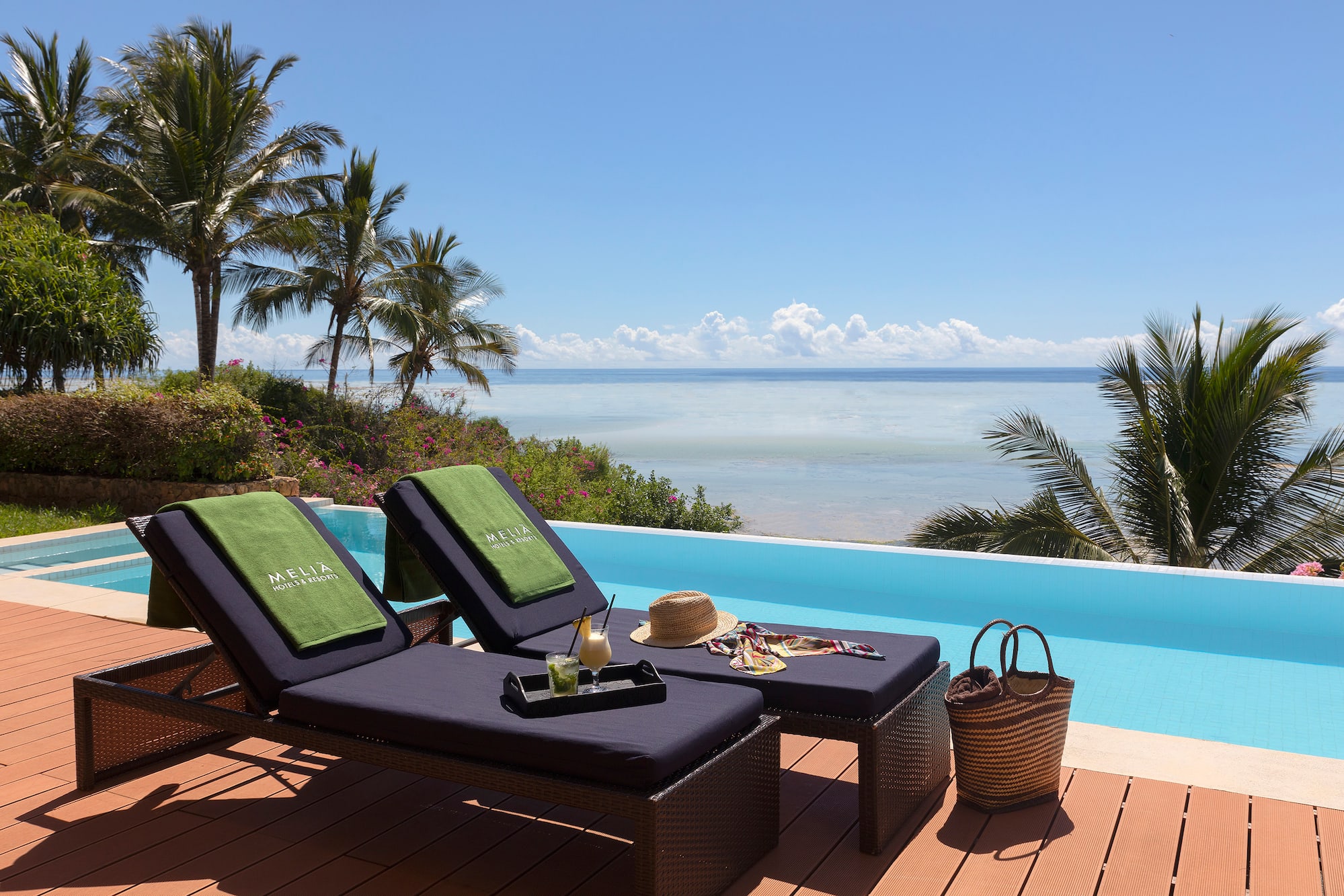 a lounge chairs on a deck overlooking a pool