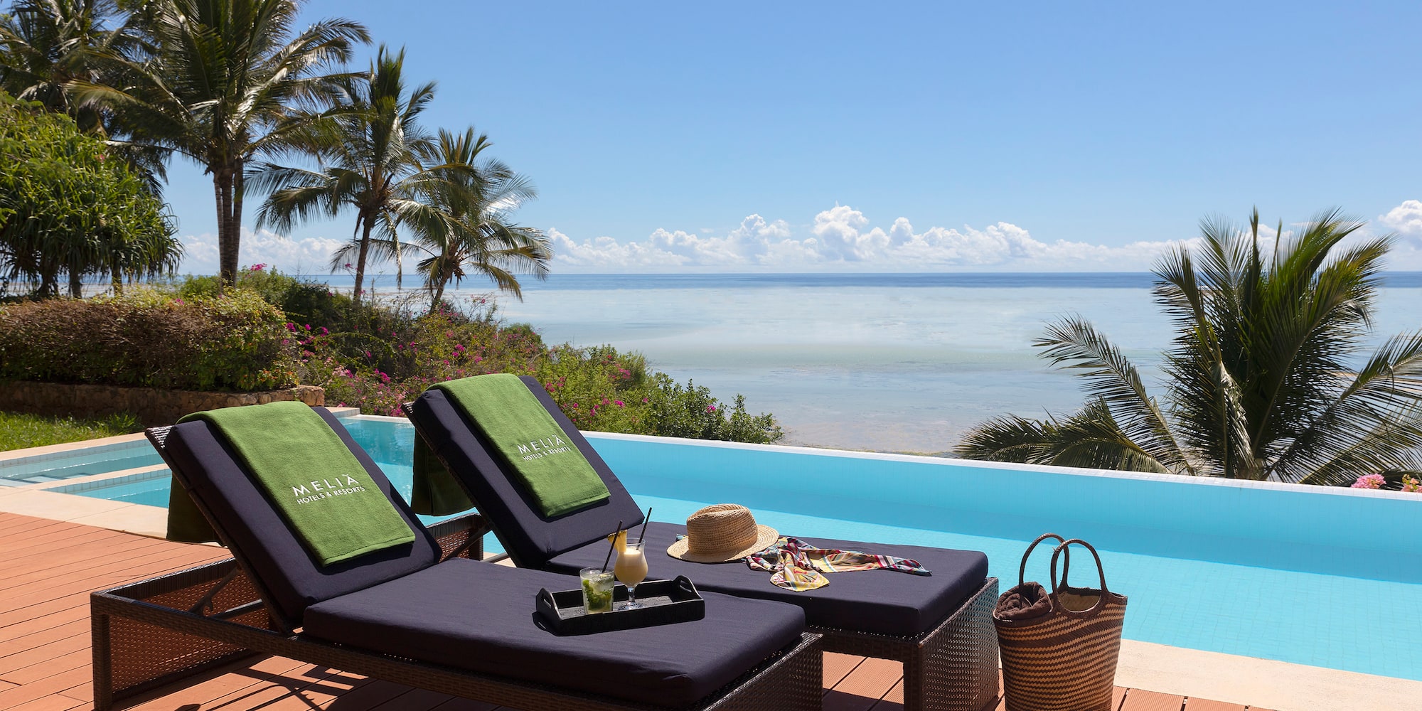 a lounge chairs on a deck overlooking a pool