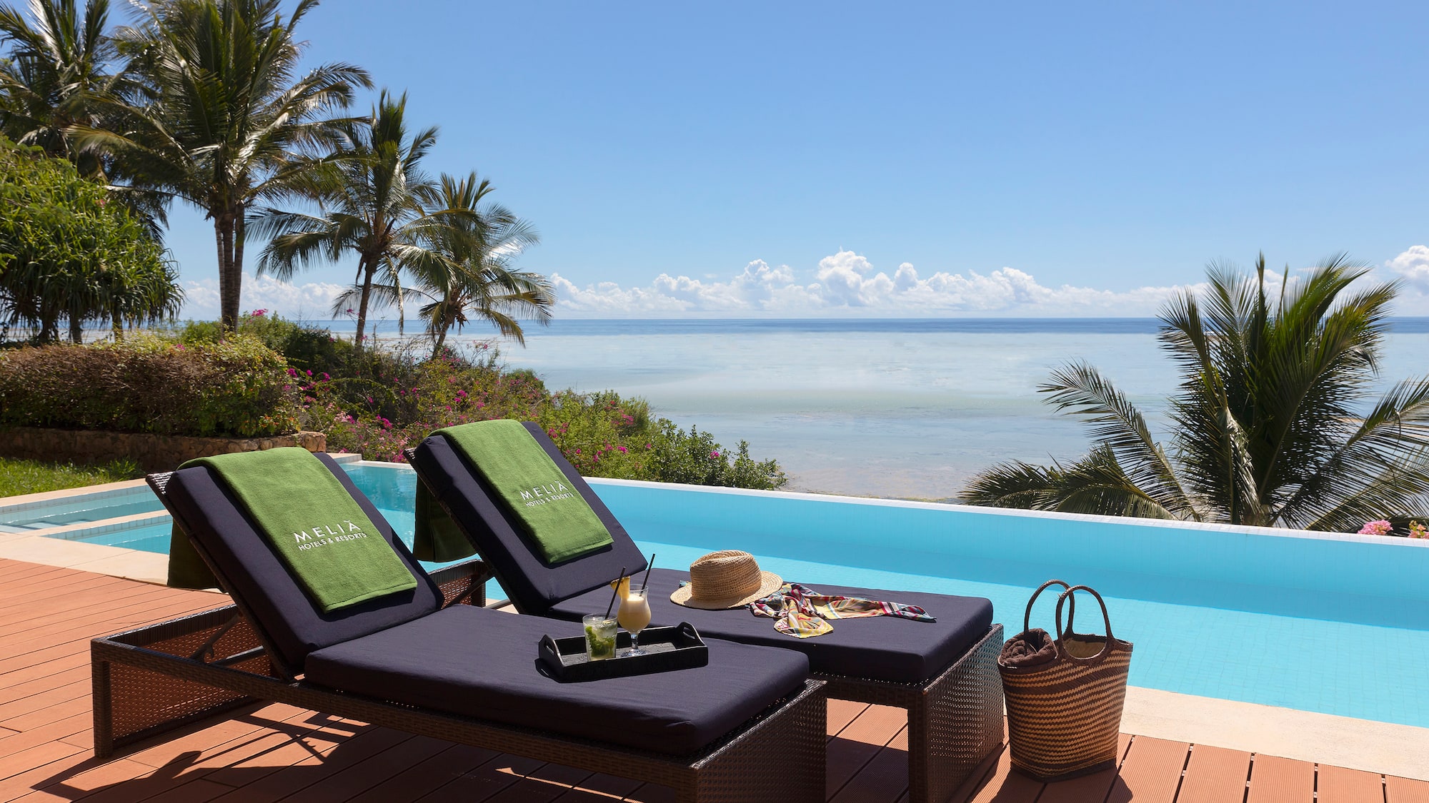 a lounge chairs on a deck overlooking a pool