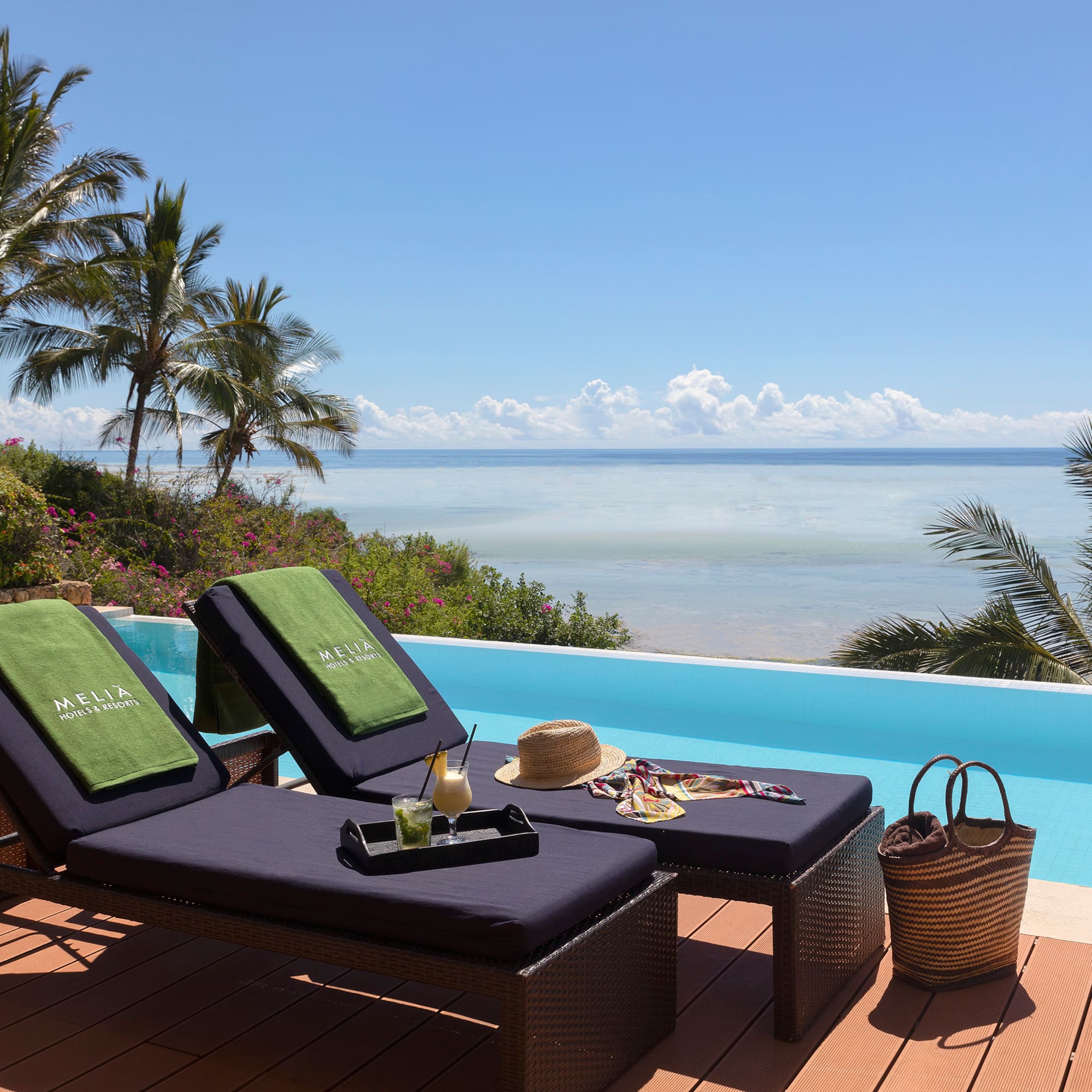 a lounge chairs on a deck overlooking a pool