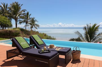 a lounge chairs on a deck overlooking a pool