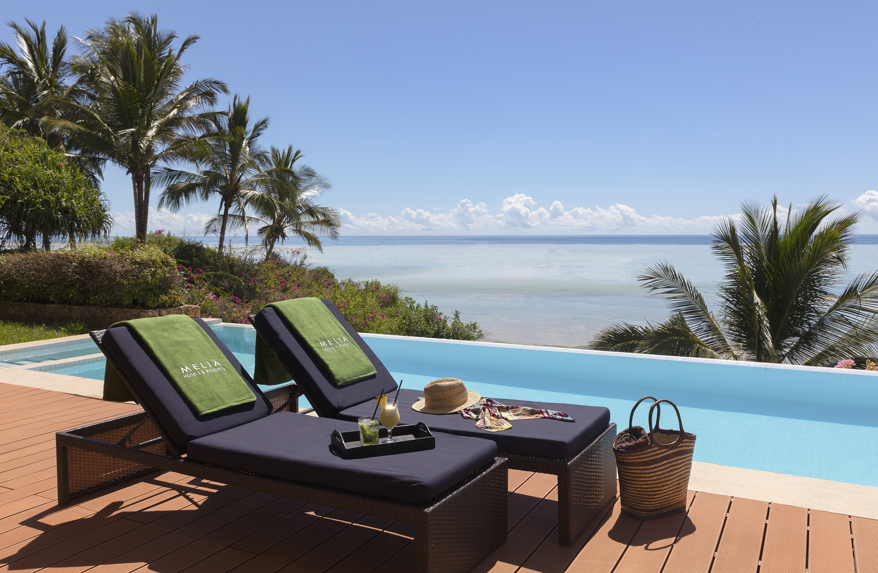 a lounge chairs on a deck overlooking a pool
