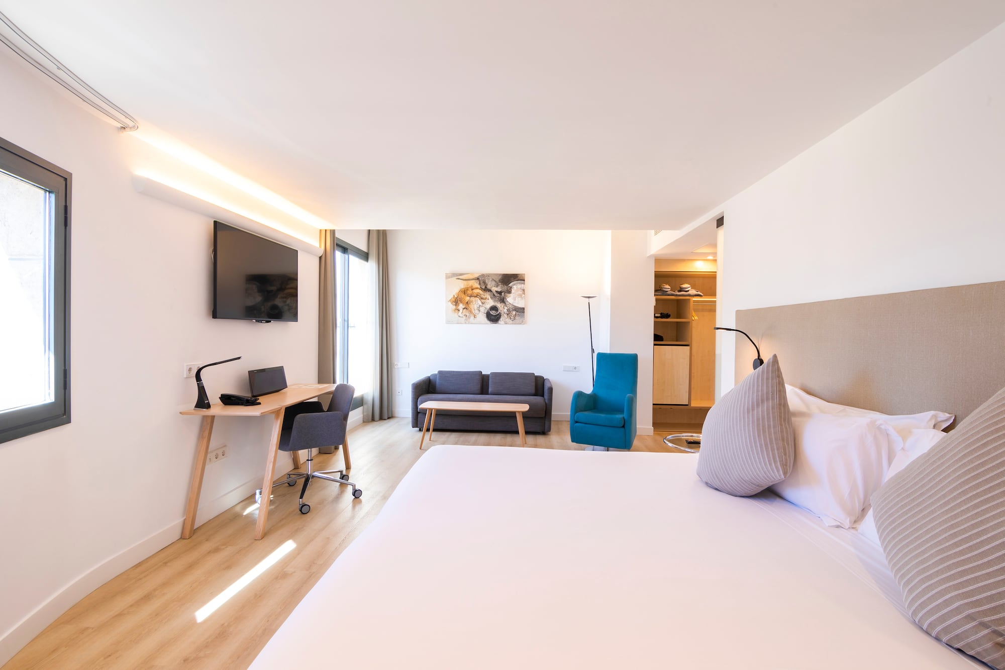 a room with a bed and a desk and a tv