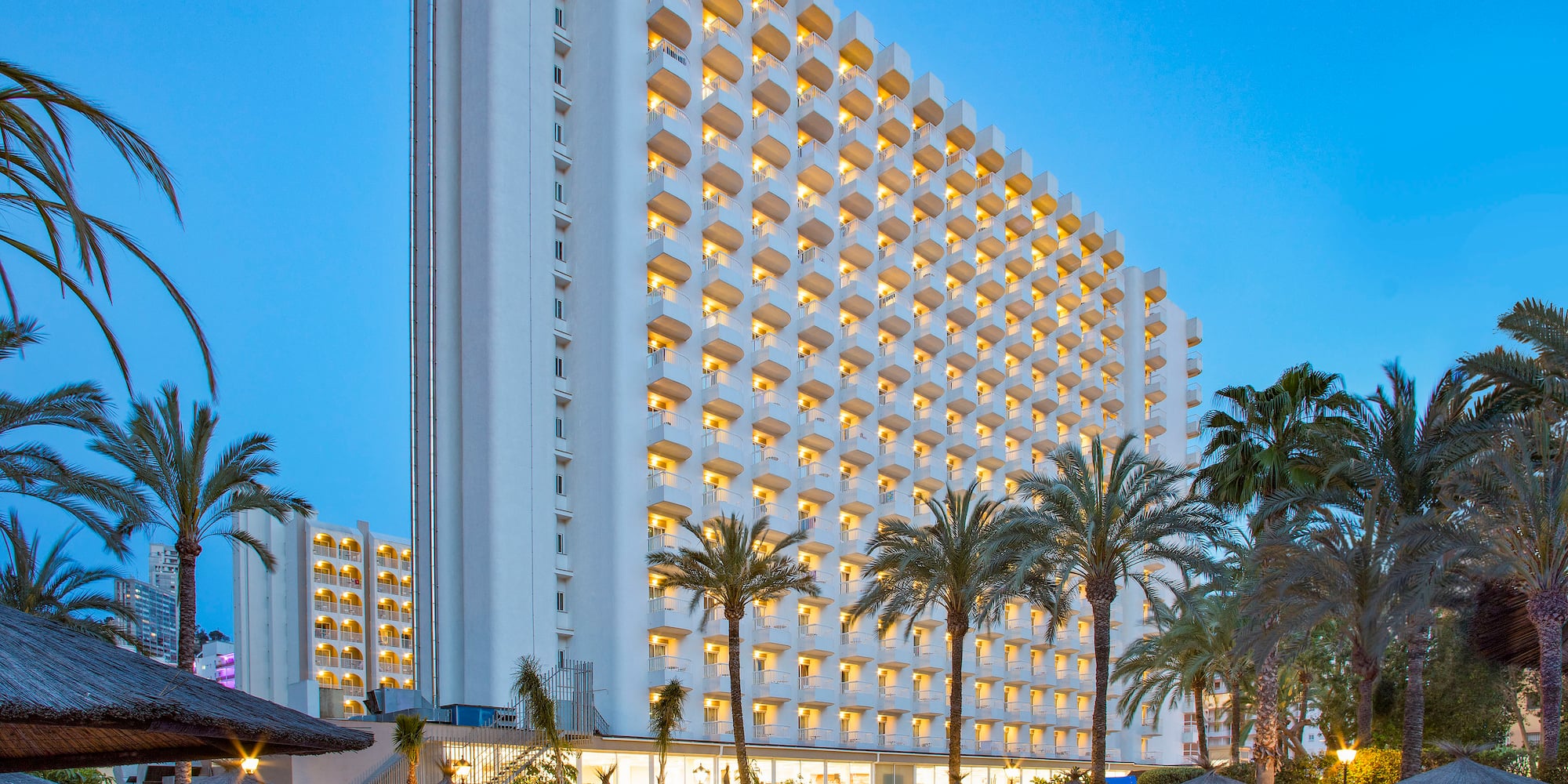 a large building with a pool and palm trees