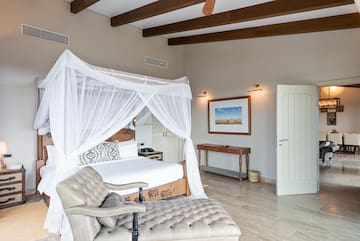 a bedroom with a canopy bed and a chair