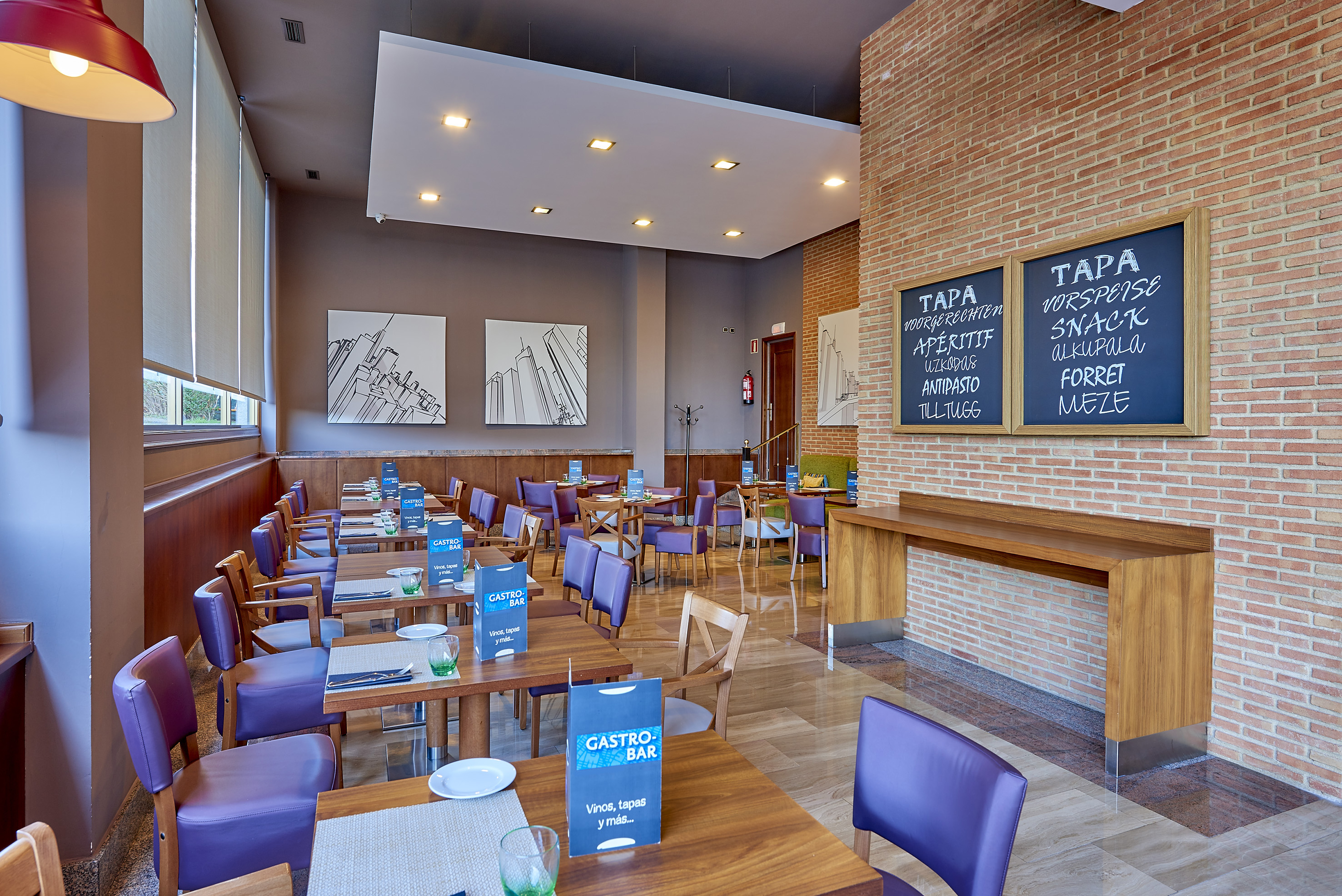 Modern gastro bar with purple chairs, wooden tables, and tapas signage.