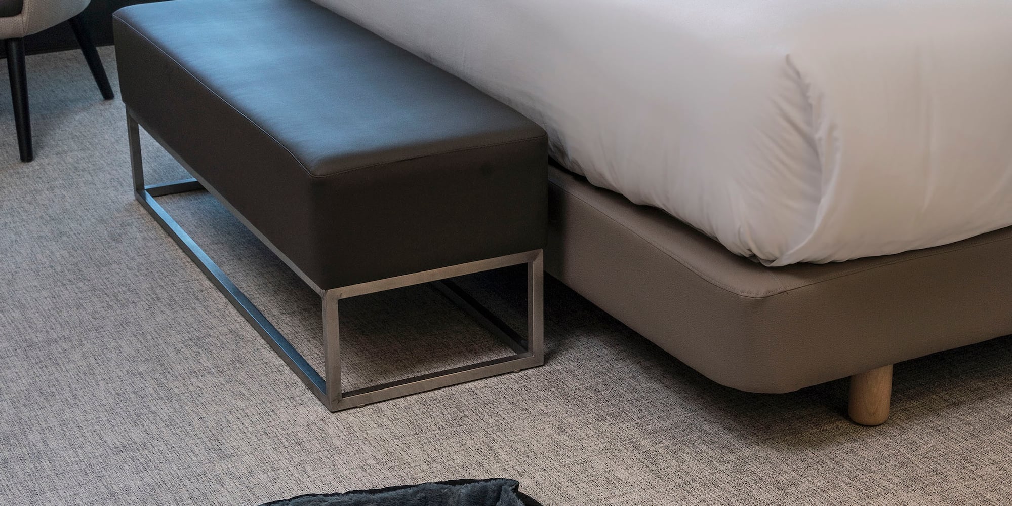 a bed with a dog bed and a dog bowl