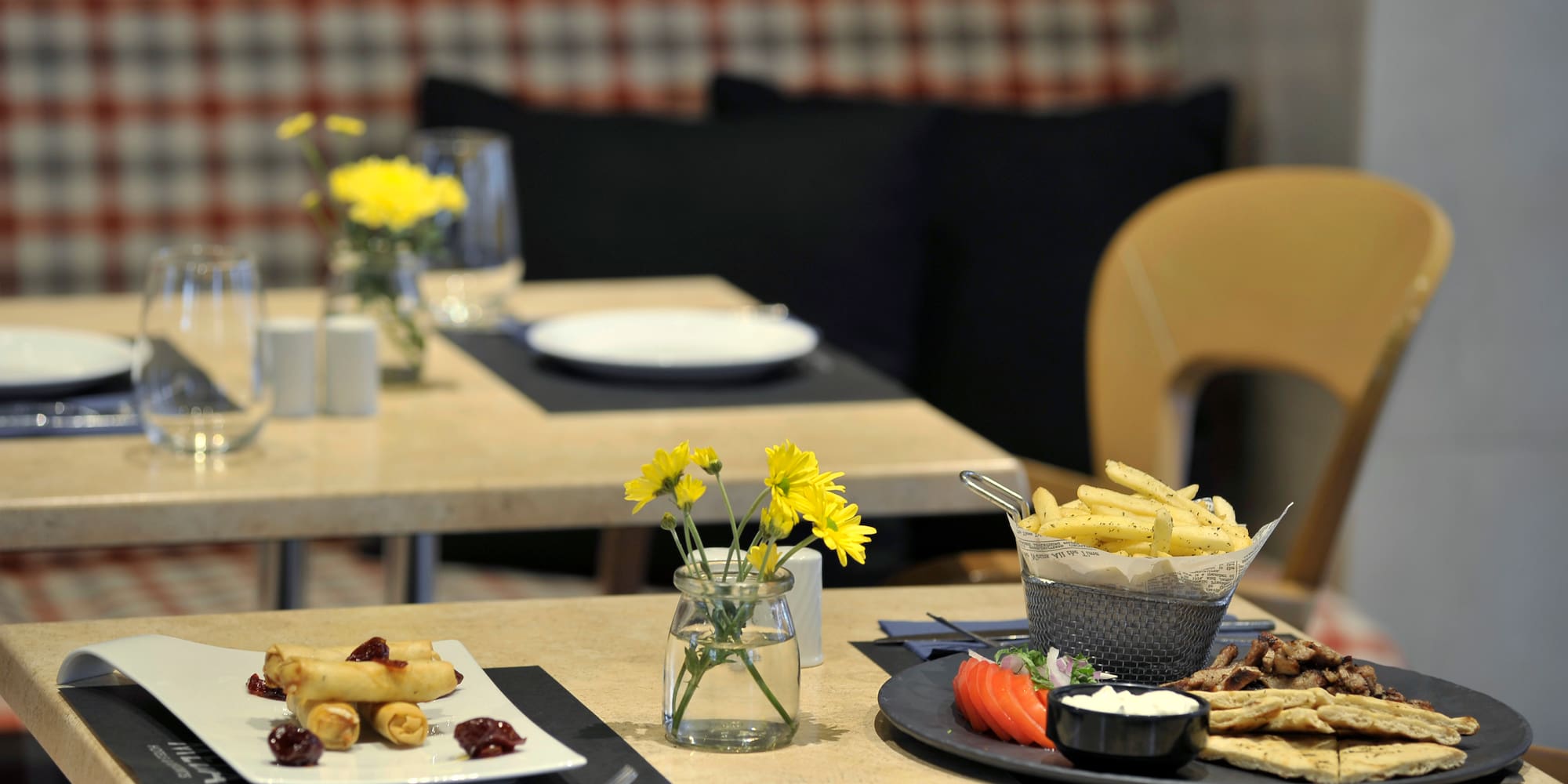 a table with plates of food and flowers