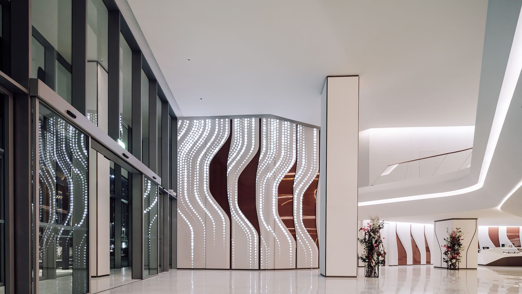 a large white and brown room with glass doors and a vase of flowers