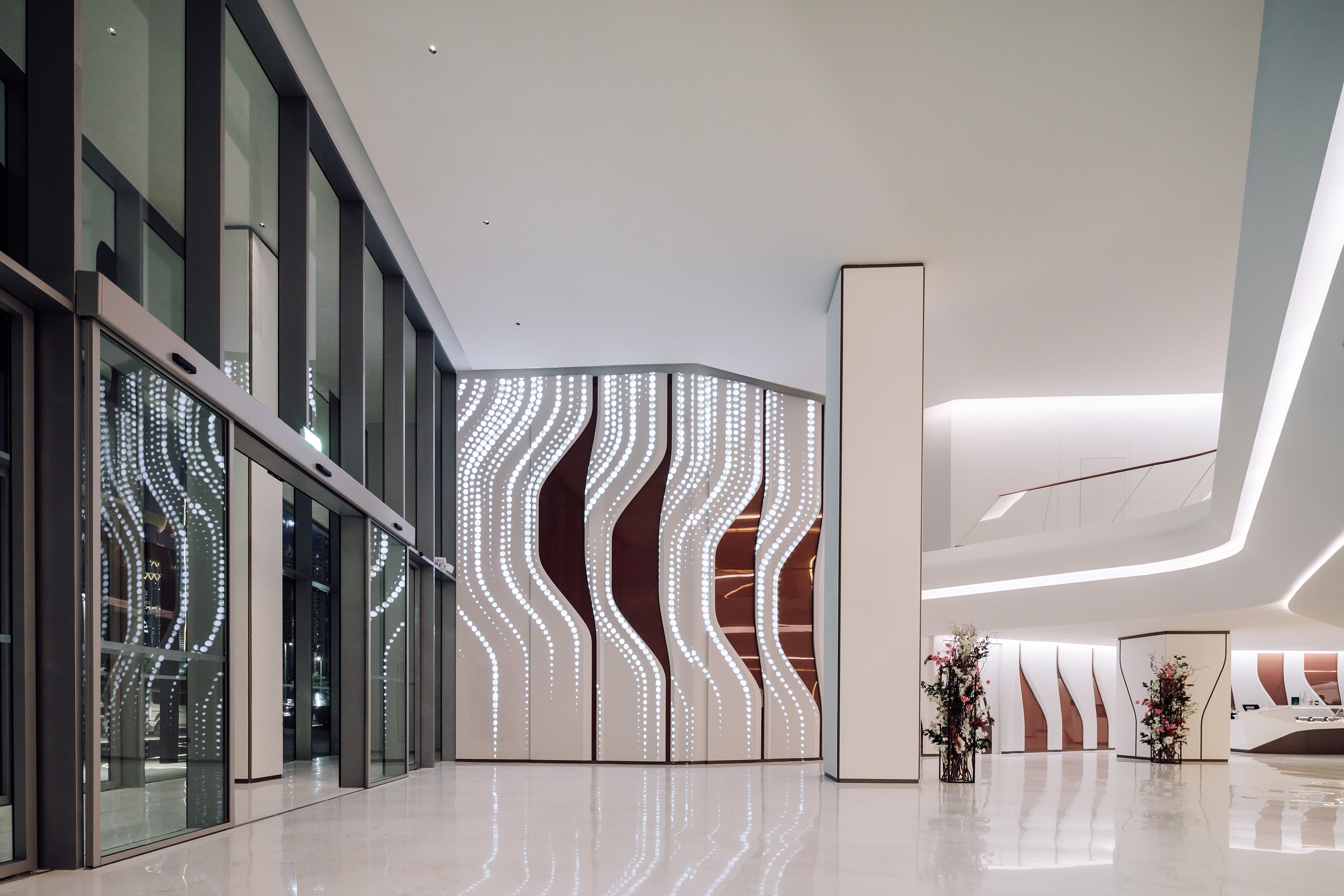 a large white and brown room with glass doors and a vase of flowers