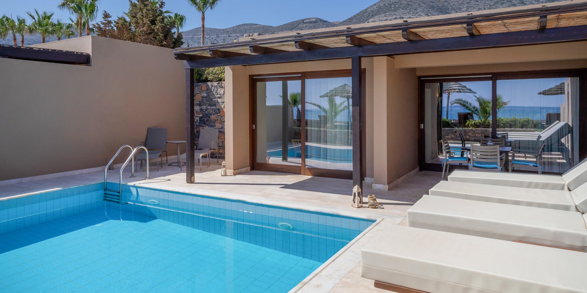 a pool and chairs next to a house