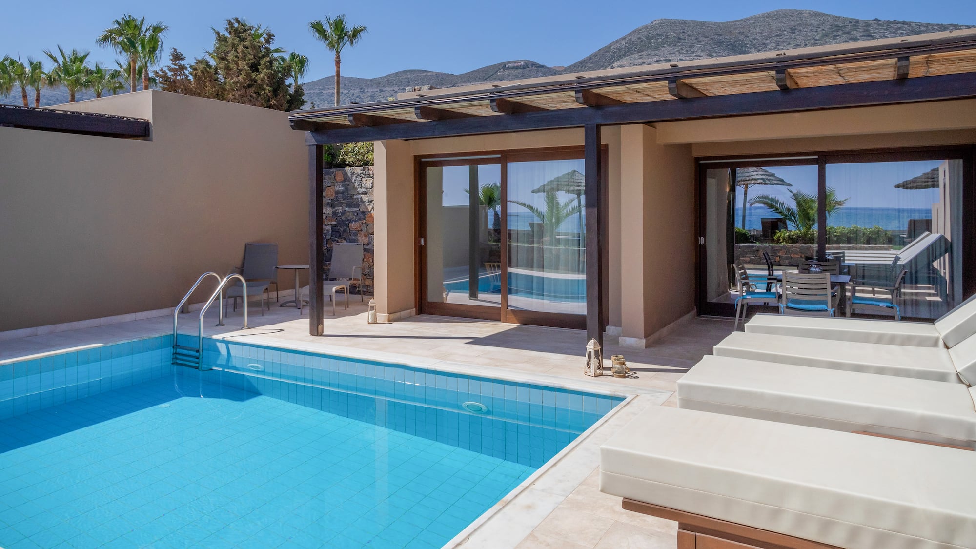 a pool and chairs next to a house