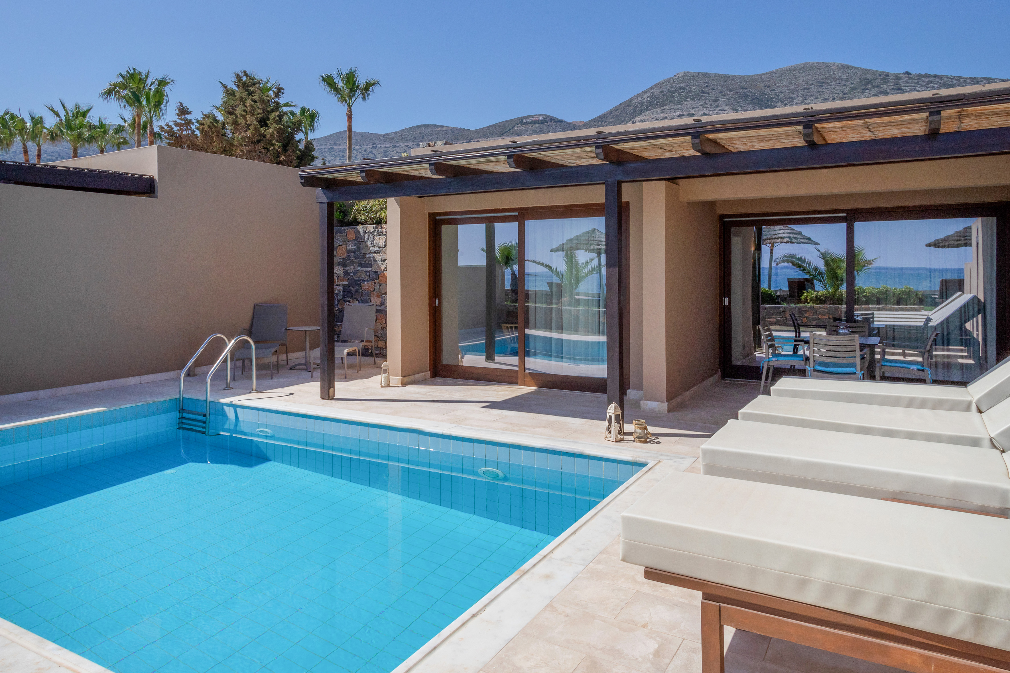 a pool and chairs next to a house