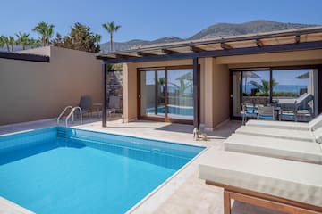 a pool and chairs next to a house