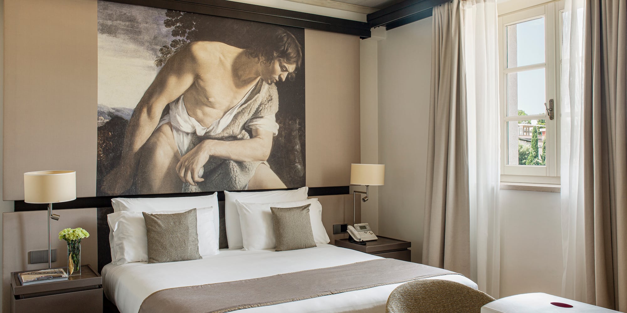 a bedroom with a large painting on the wall