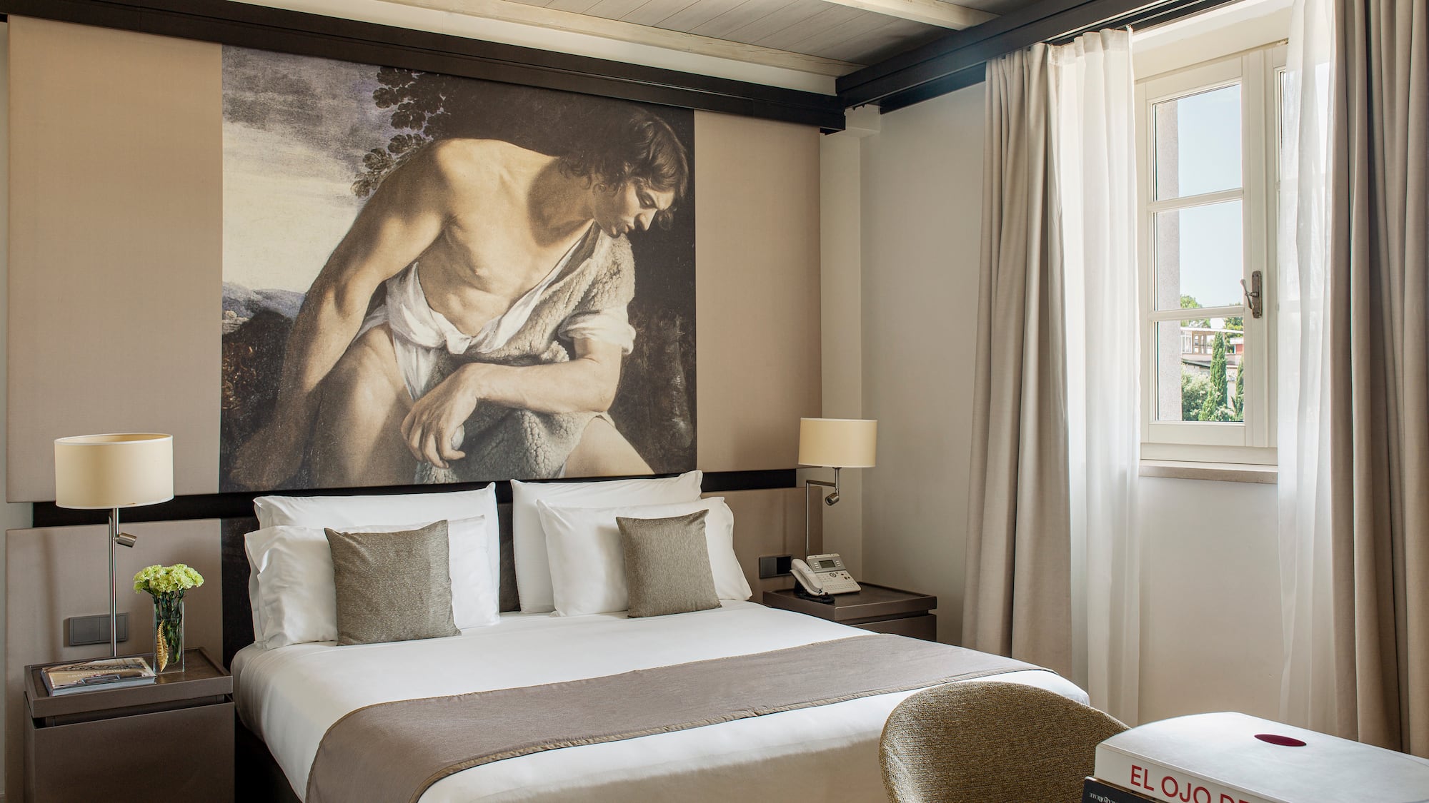 a bedroom with a large painting on the wall