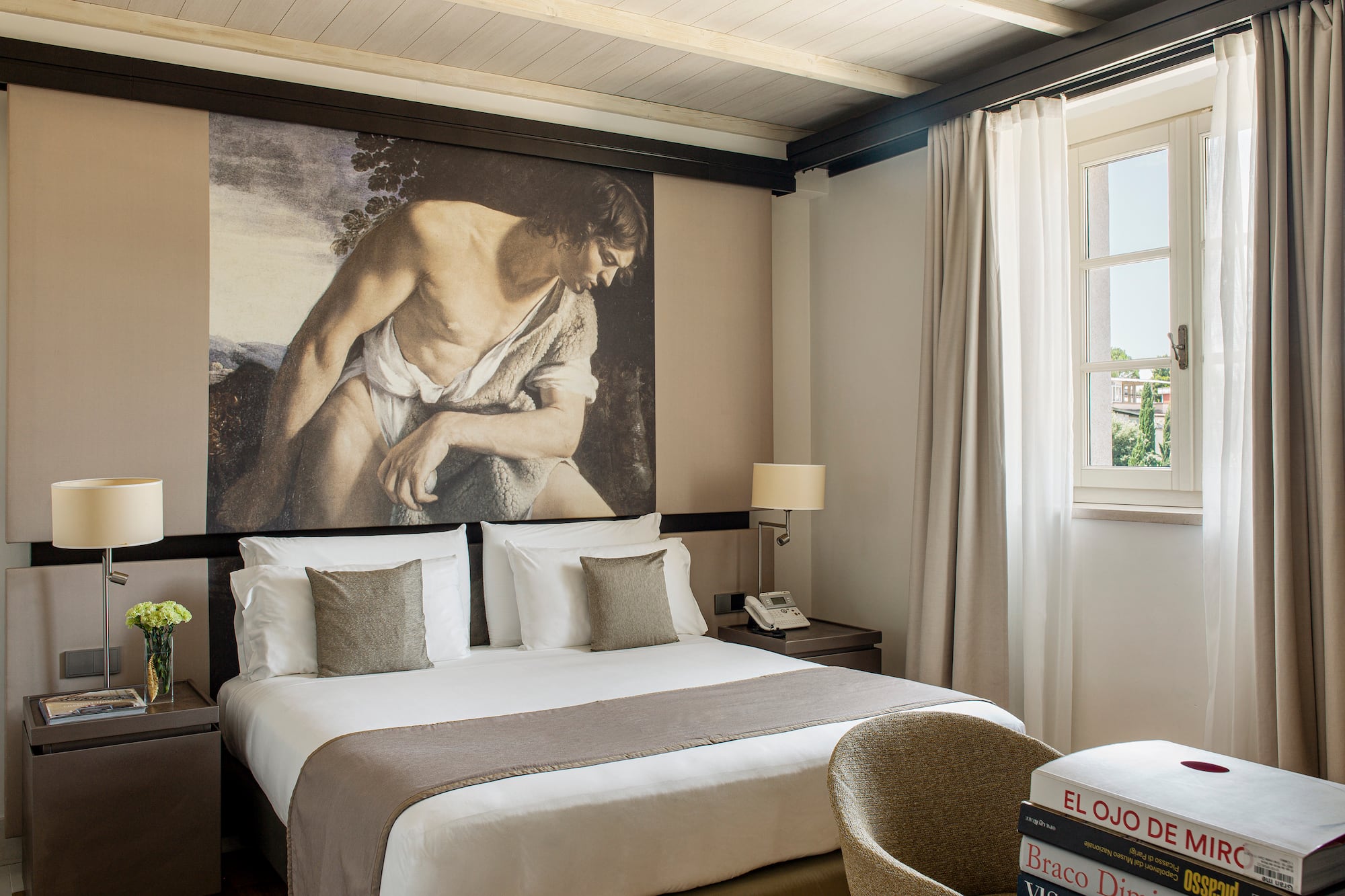 a bedroom with a large painting on the wall