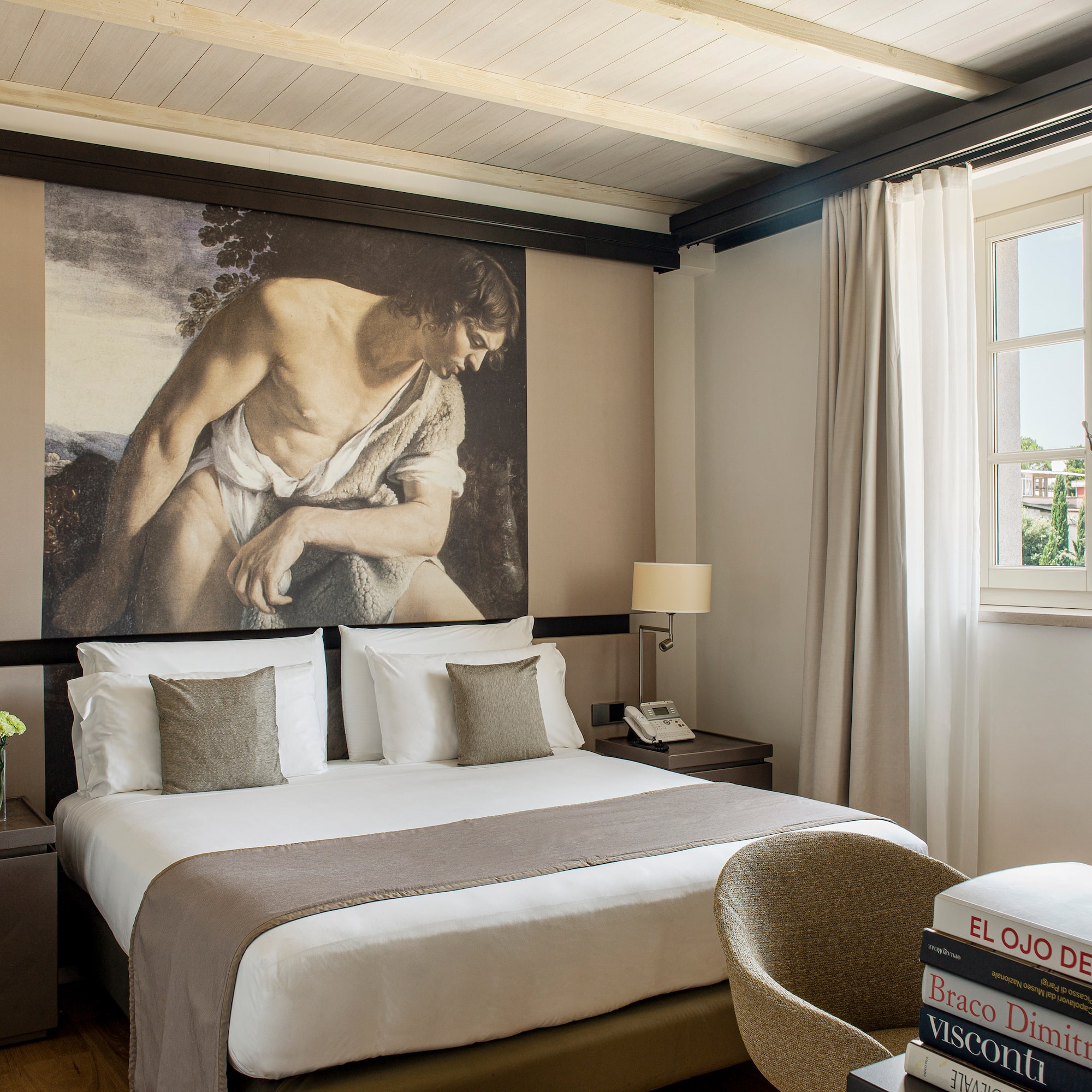a bedroom with a large painting on the wall