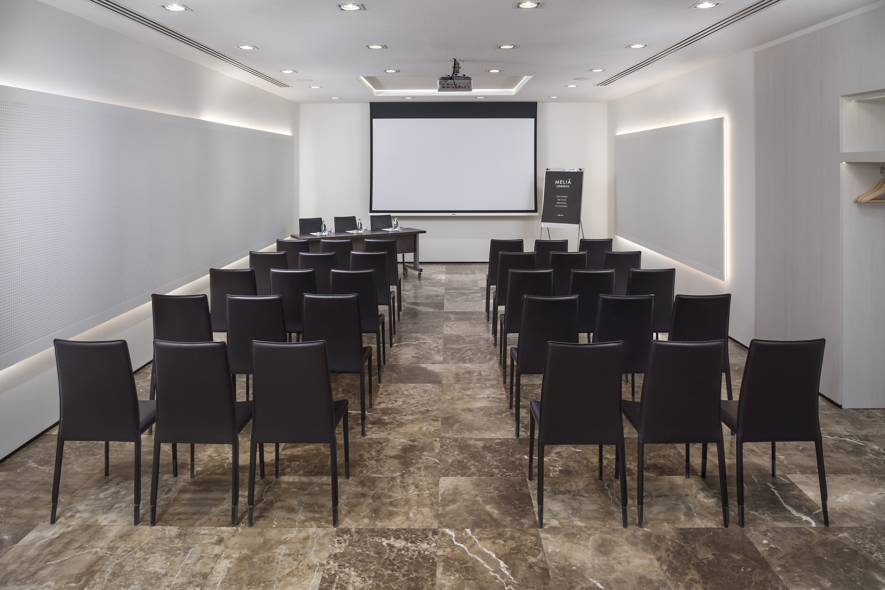 a room with chairs and a projector screen