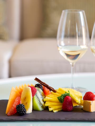 a plate of fruit and a couple wine glasses on a table