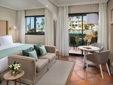 a room with a bed and a table and chairs