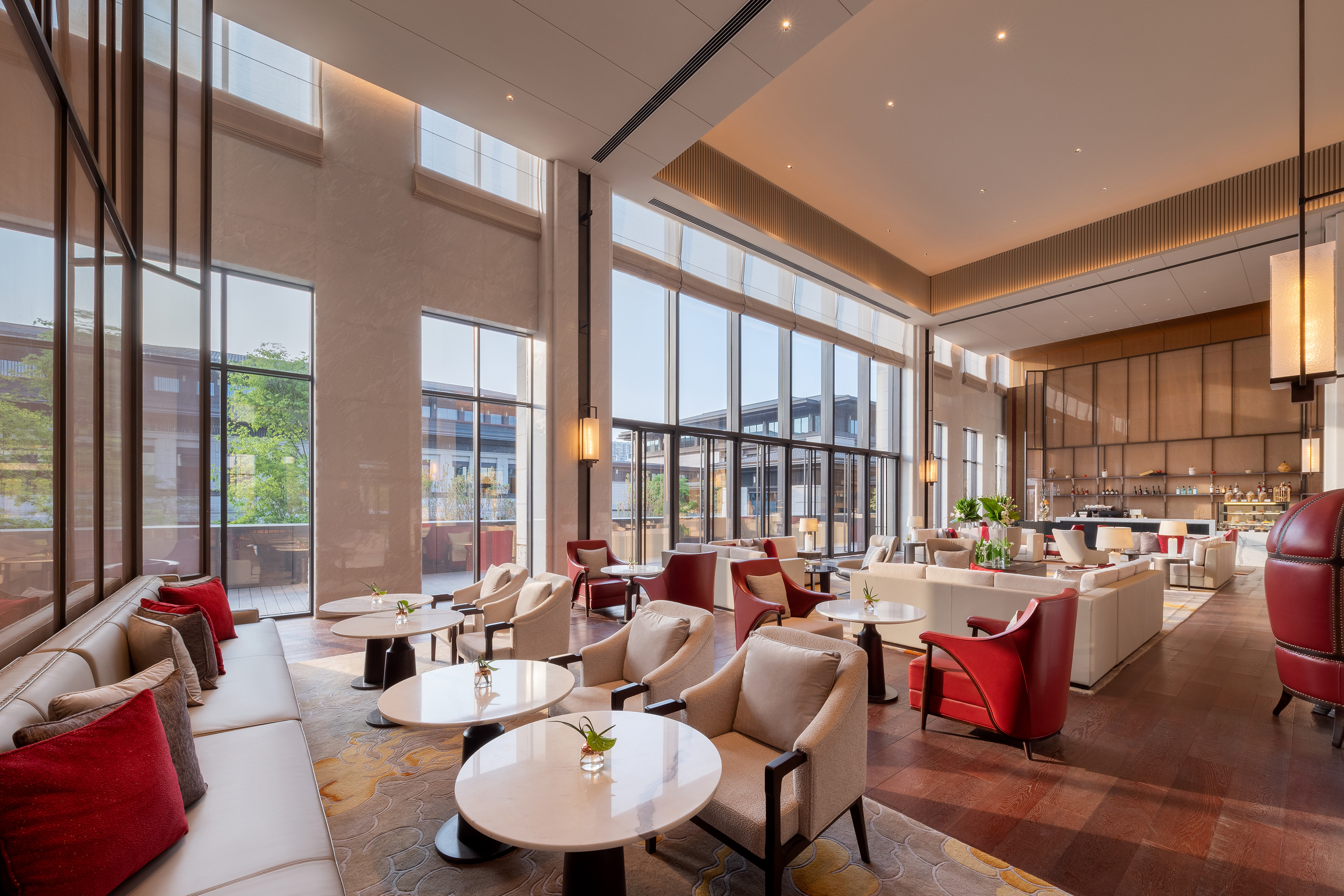 Spacious hotel lounge with contemporary seating, floor-to-ceiling windows.