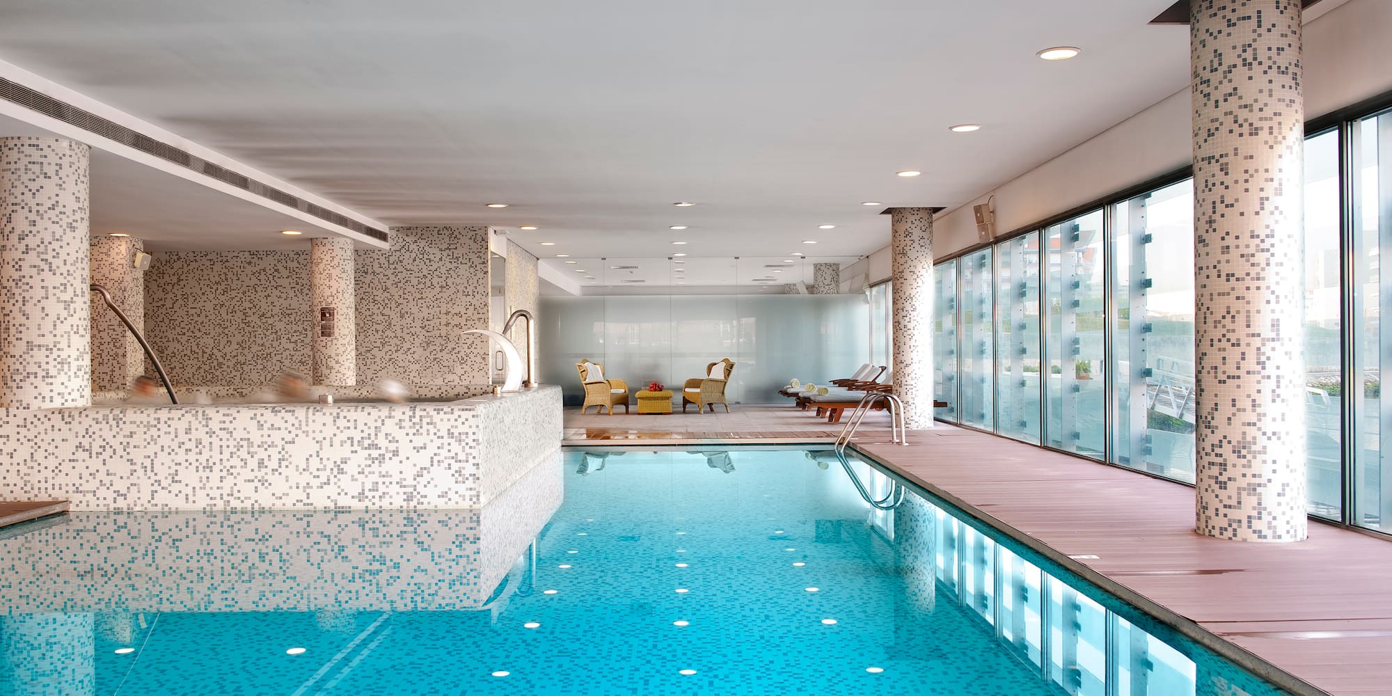 a indoor swimming pool with a large deck and chairs