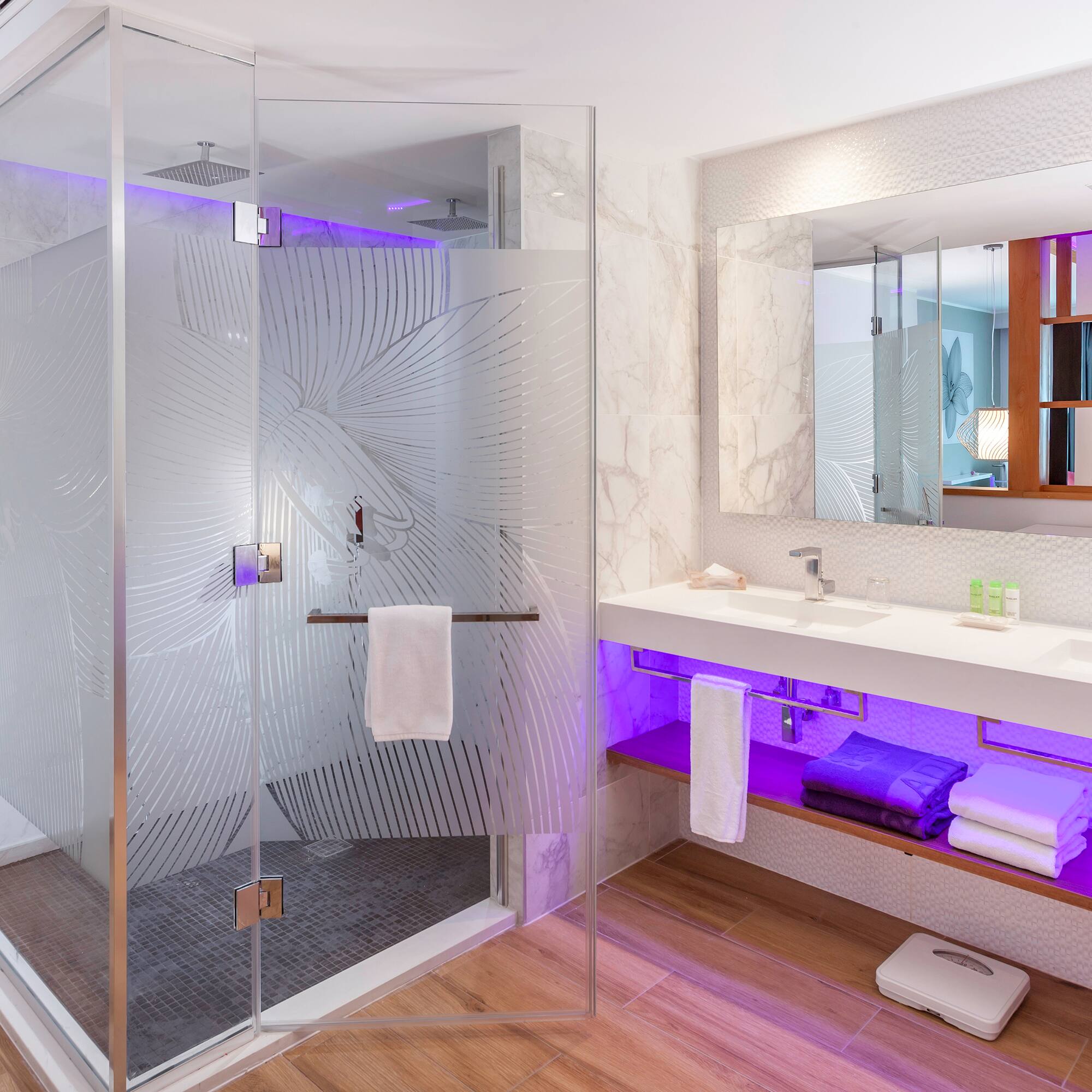 a bathroom with a glass shower and a sink