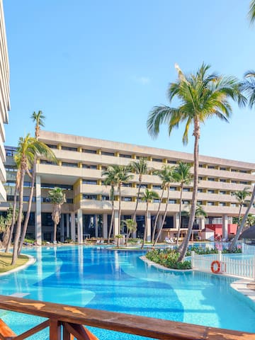 a pool with palm trees and a building
