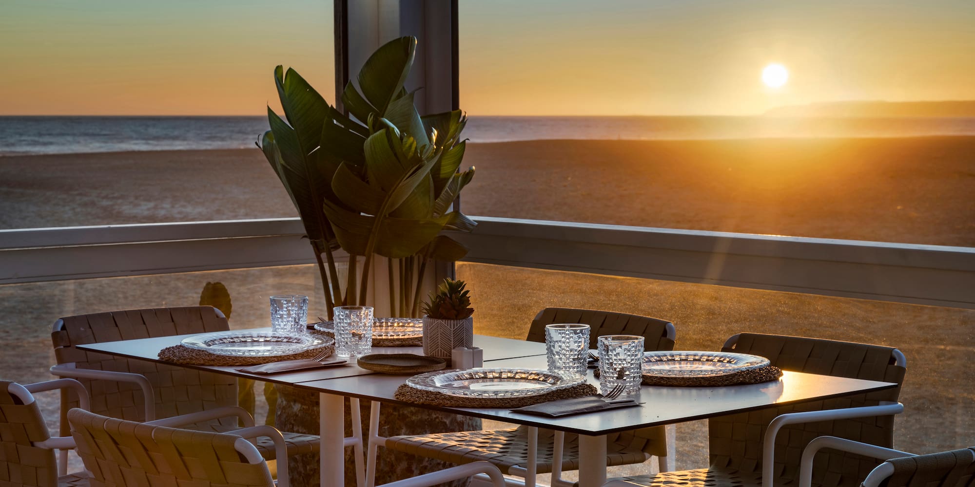 a table set up on a balcony overlooking the ocean