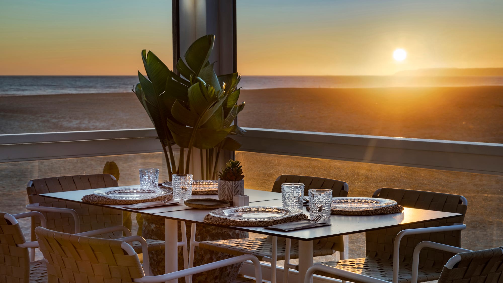 a table set up on a balcony overlooking the ocean