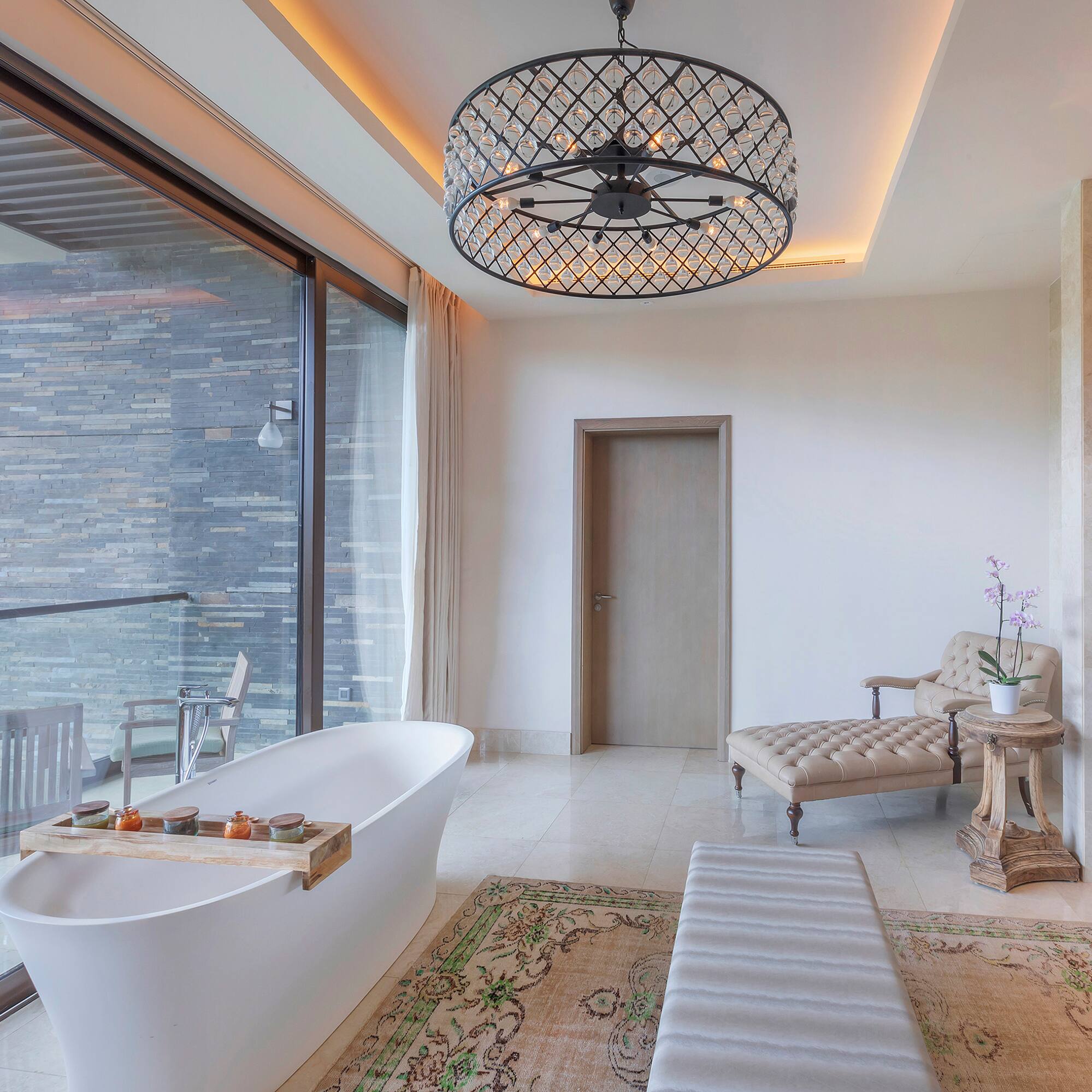 a bathroom with a tub and a chandelier