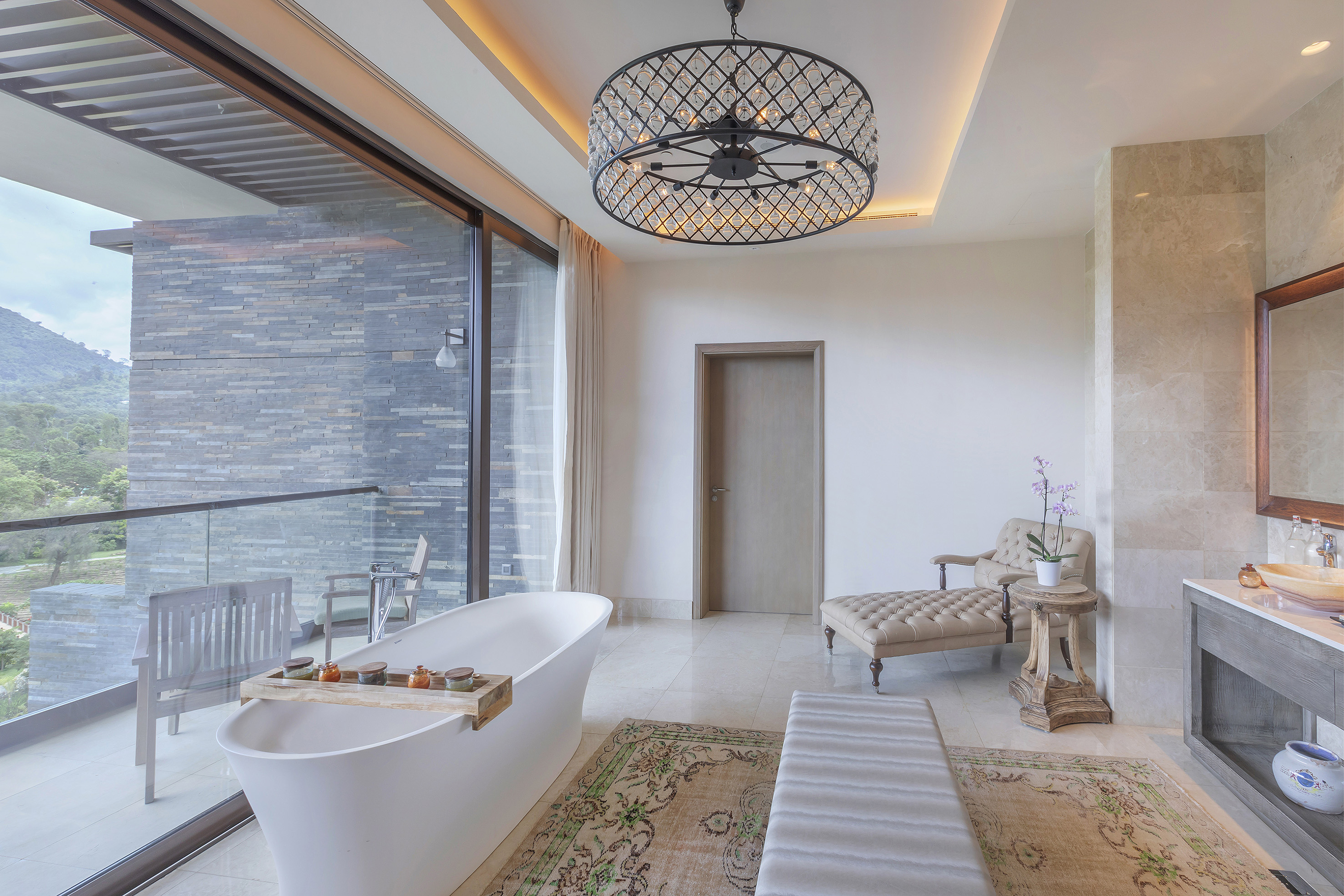 Luxurious bathroom with soaking tub overlooking a mountain view balcony.