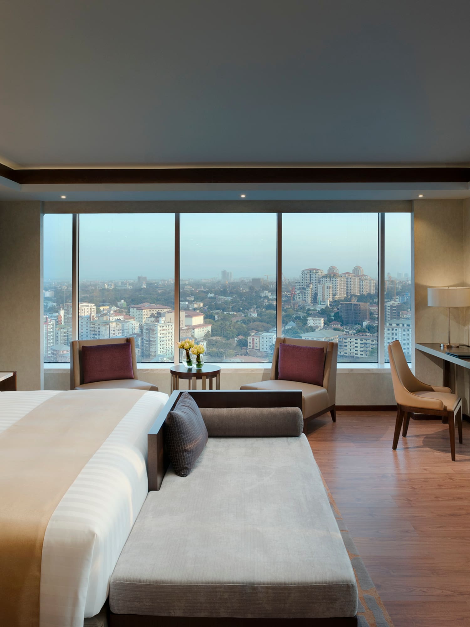 a room with a large bed and a desk and chairs