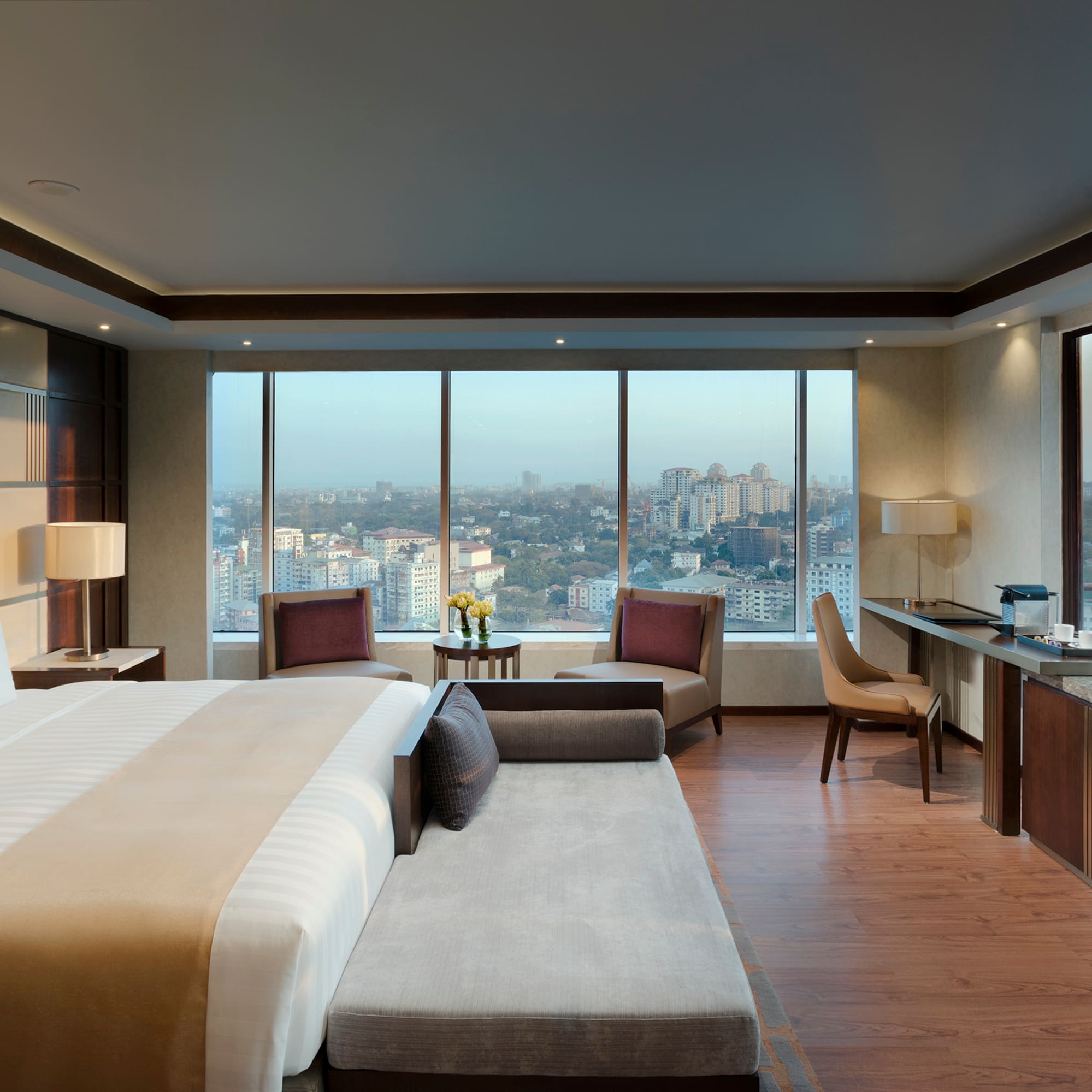 a room with a large bed and a desk and chairs