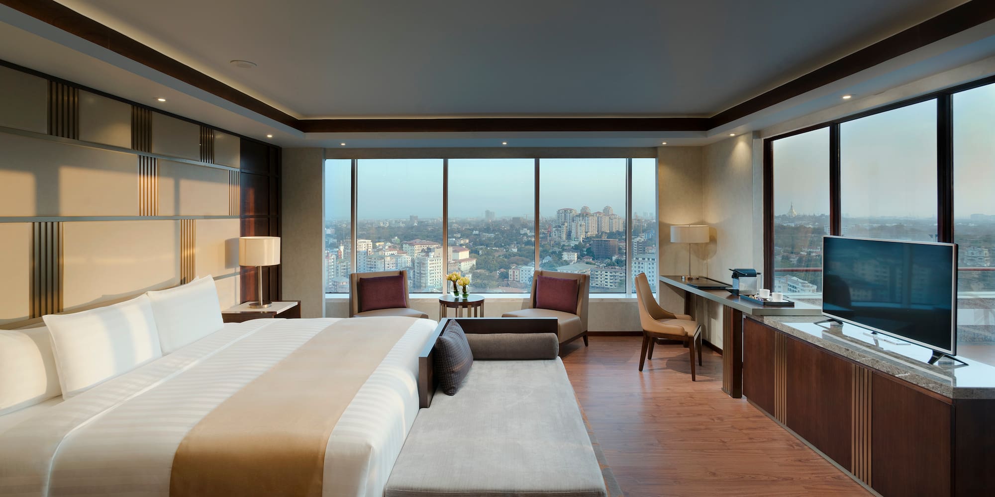 a room with a large bed and a desk and chairs