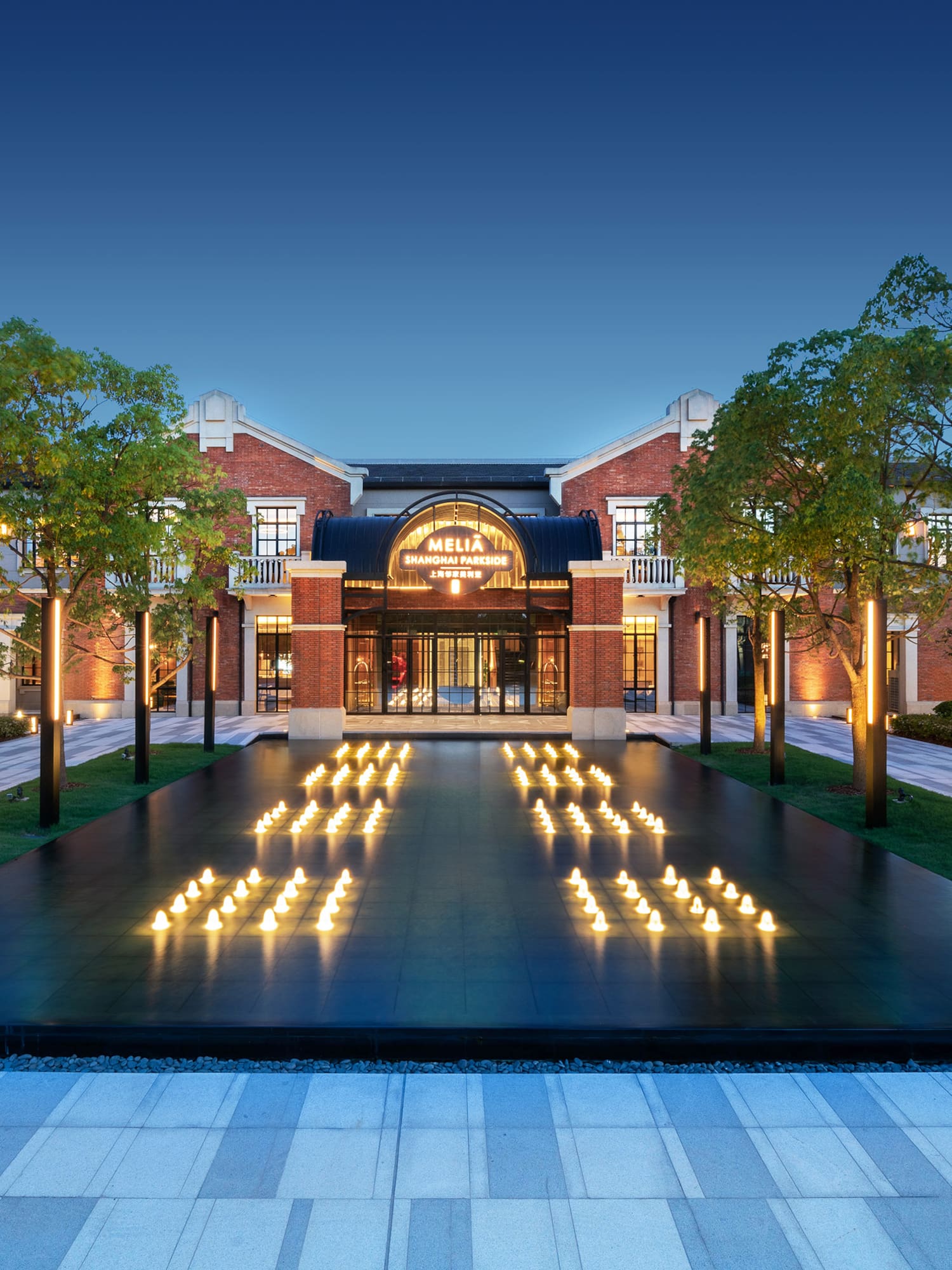 a building with trees and a fountain with lit candles