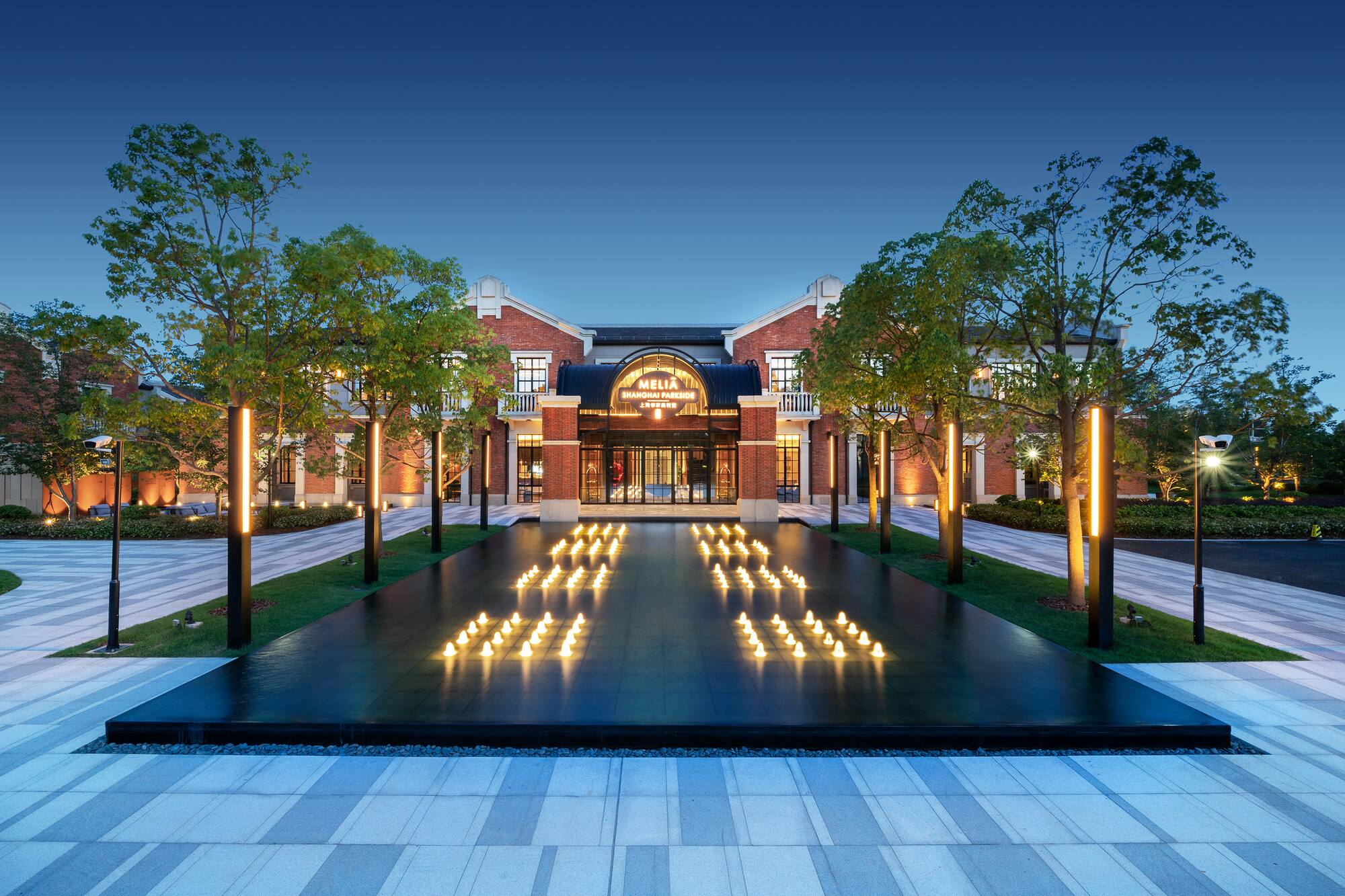 Meliá Shanghai Parkside hotel exterior at dusk with illuminated water feature.