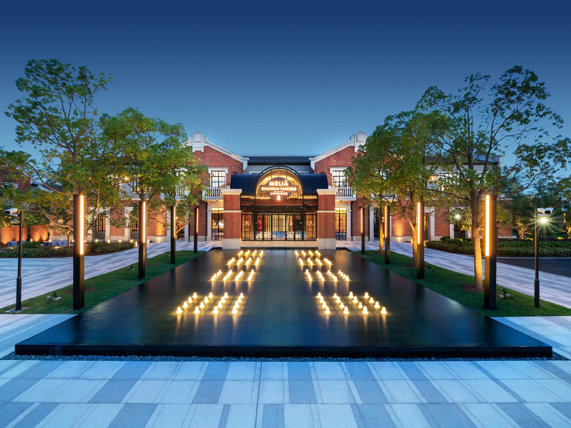 a building with trees and a fountain with lit candles