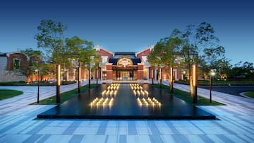 a building with trees and a fountain with lit candles