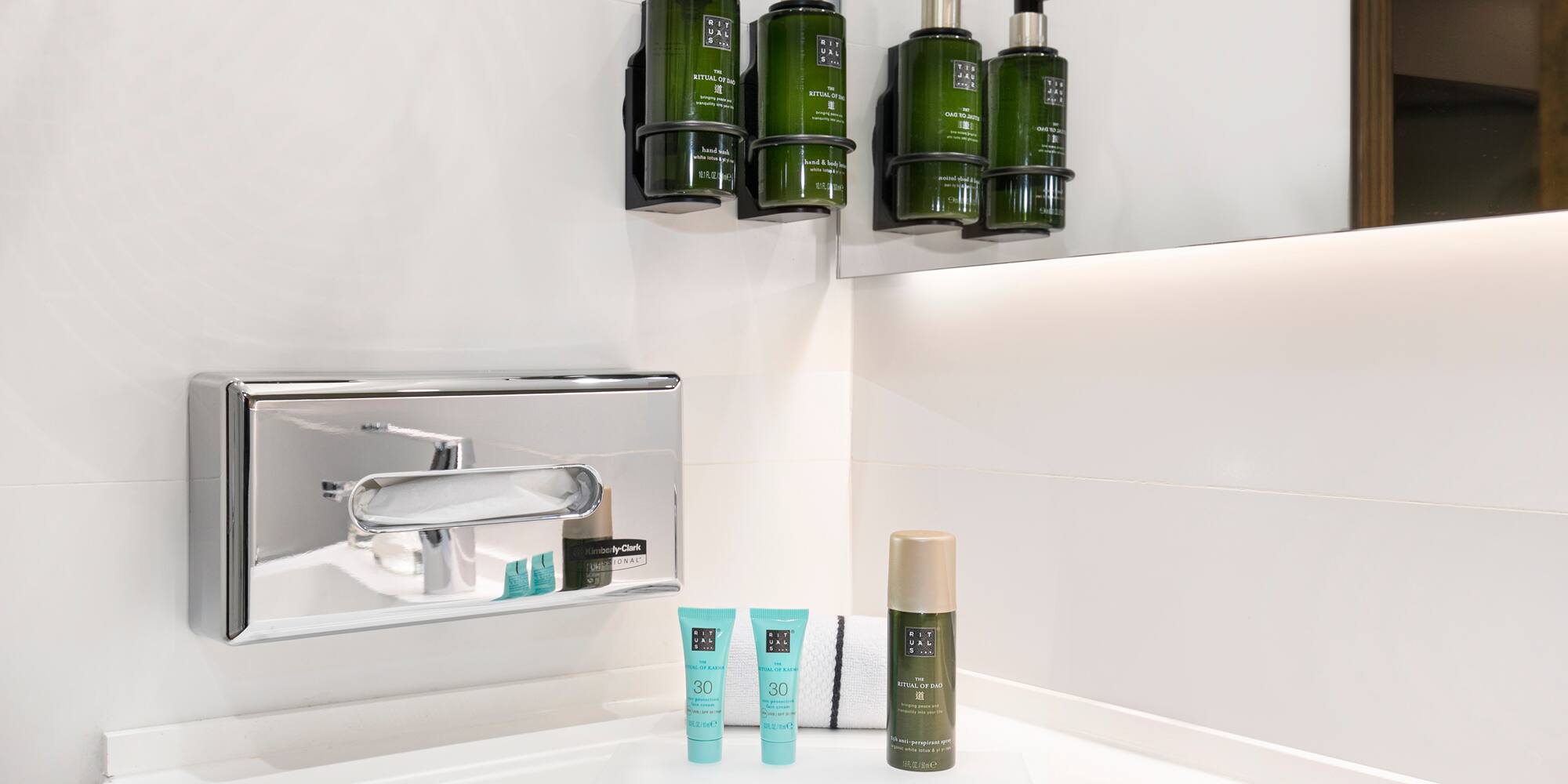 a bathroom with a sink and a group of green bottles