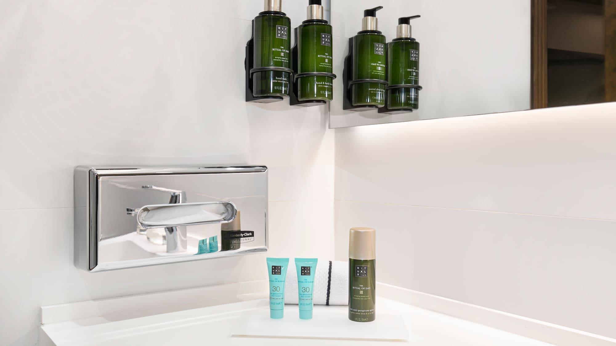 a bathroom with a sink and a group of green bottles