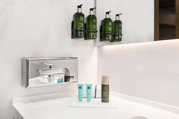 a bathroom with a sink and a group of green bottles