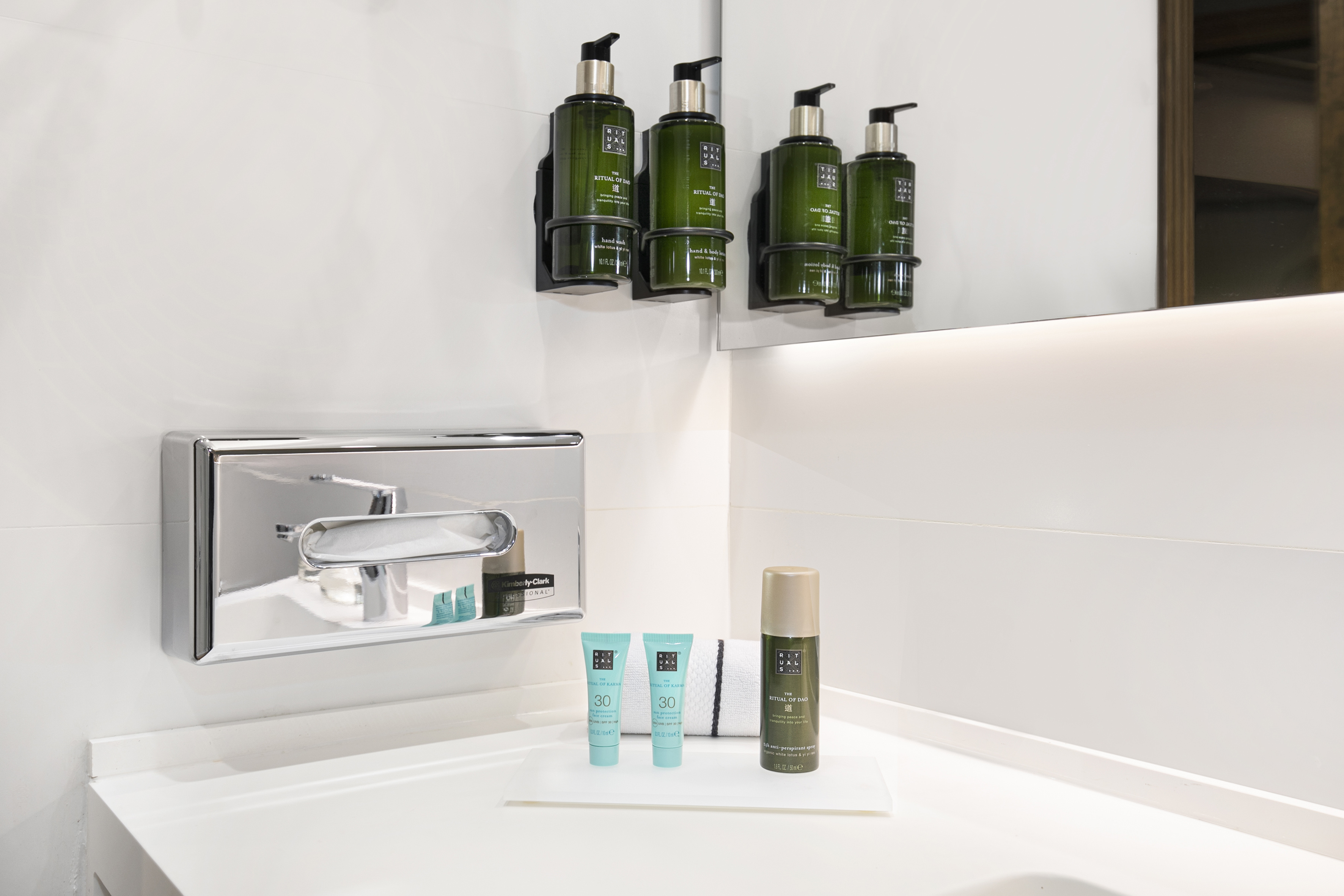 Rituals green hand wash, body lotion, SPF, and deodorant in a clean bathroom.