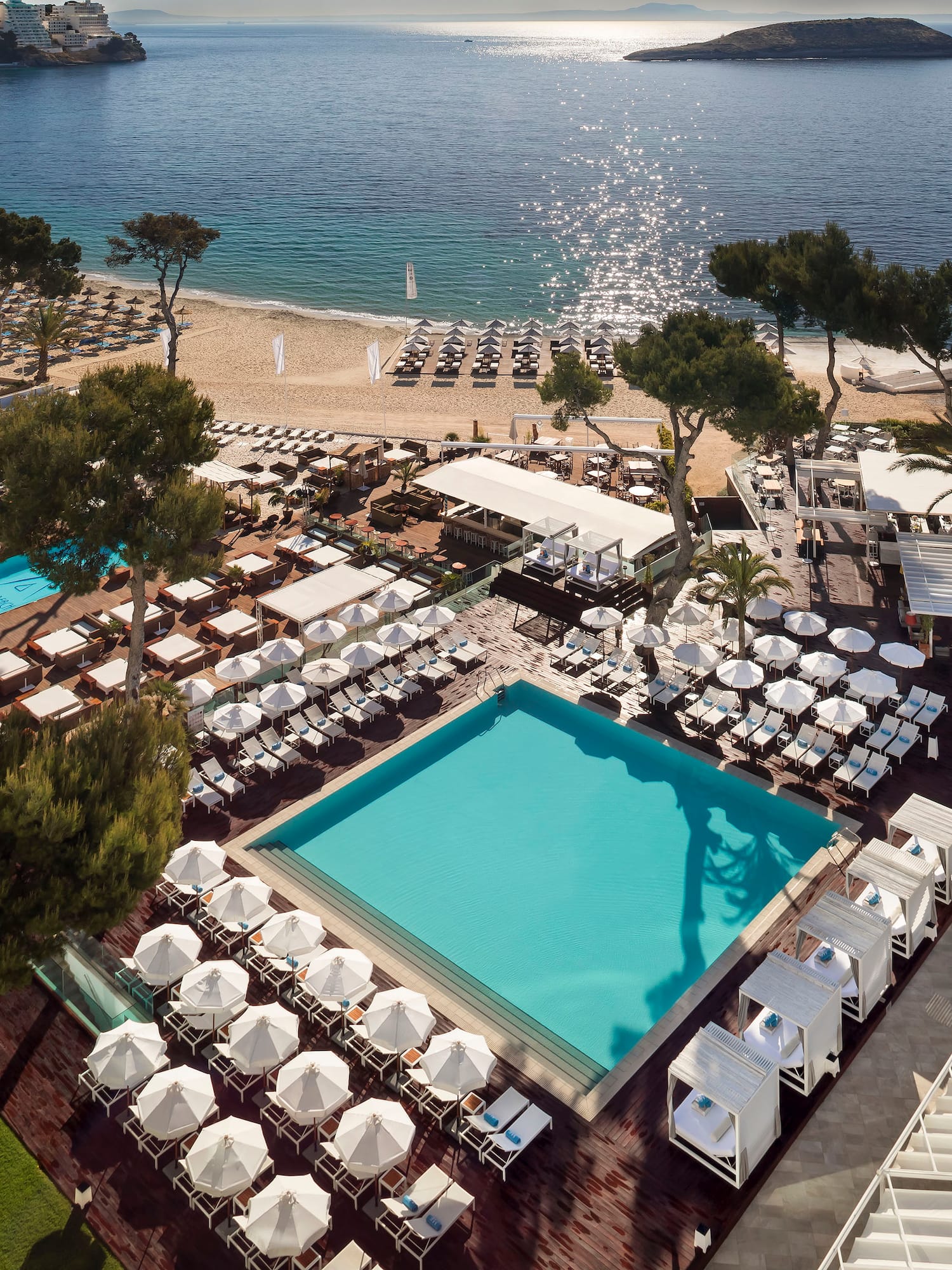 a pool and chairs on a beach