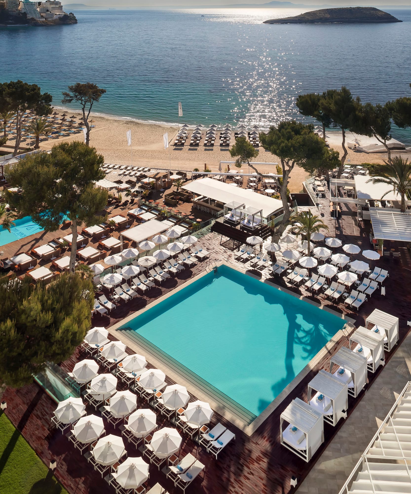 a pool and chairs on a beach