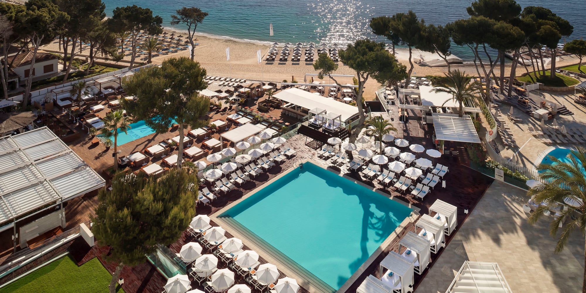 a pool and chairs on a beach