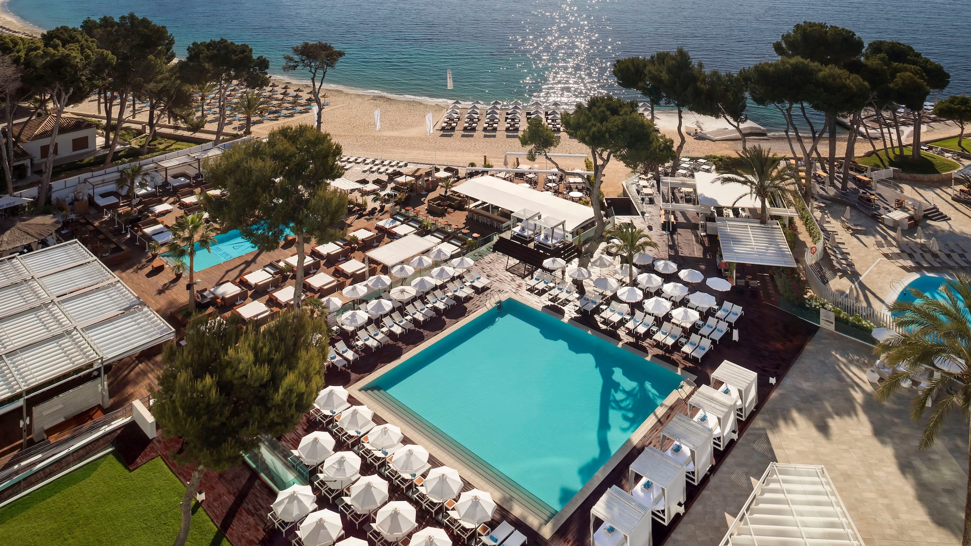 a pool and chairs on a beach