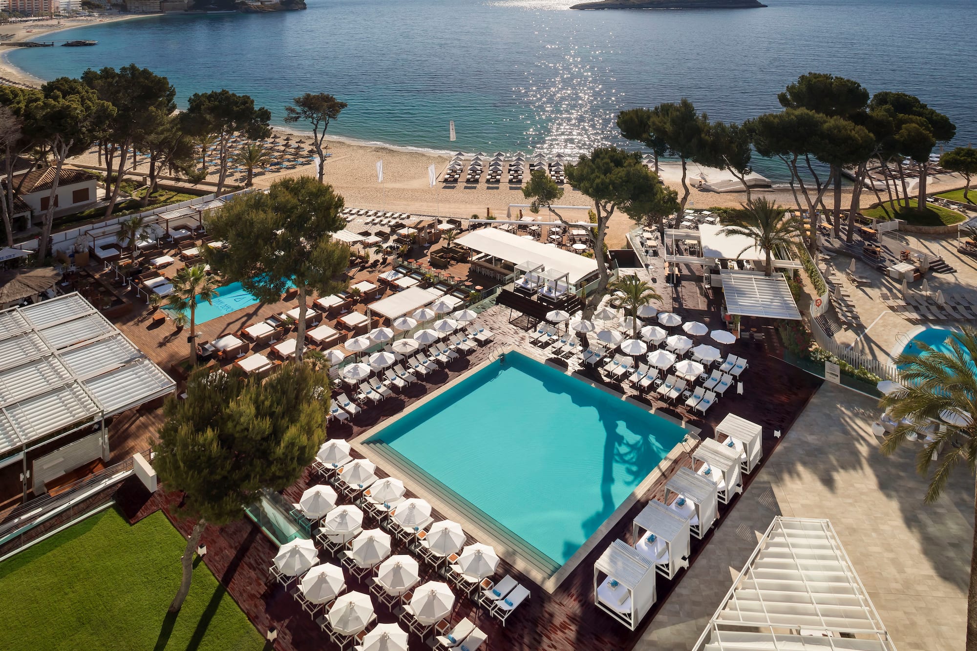 a pool and chairs on a beach